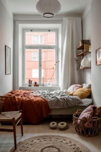 A small aparment bedroom with natural light through the windows