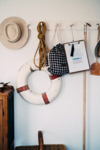 A life buoy, a rope, and a hat hung on a wall hanger