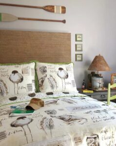 Bedroom with linen headboard and oars that give a summery feel