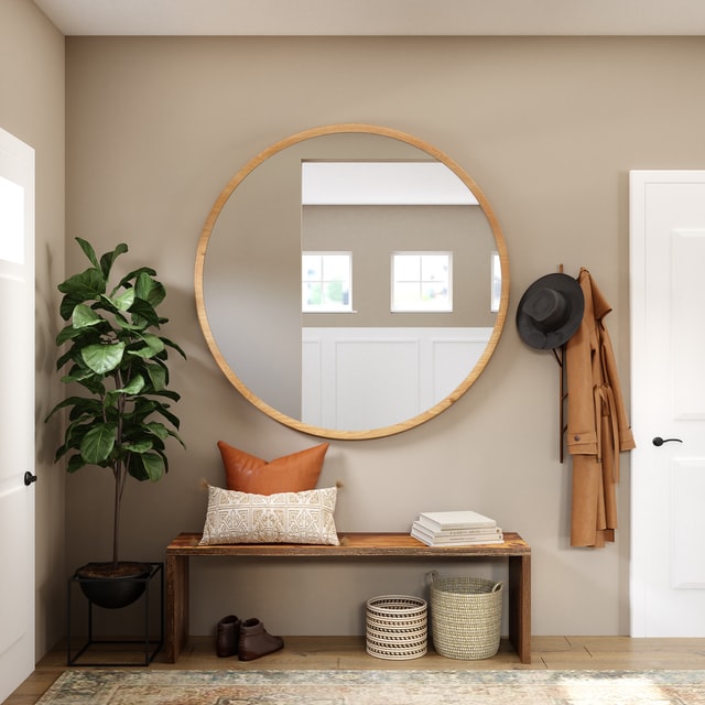 A round mirror on entryway wall