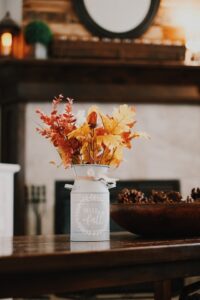 Aspen leaves in a metal jar that reads “hello fall”