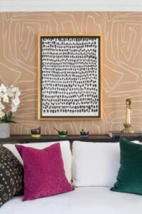 Printed wallpaper and colorful throw pillows in a small living room