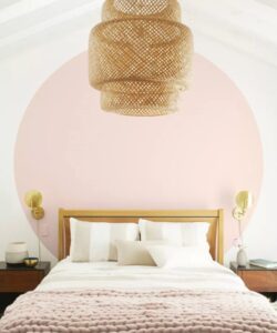 Calm bedroom with large pink painted circle behind headboard