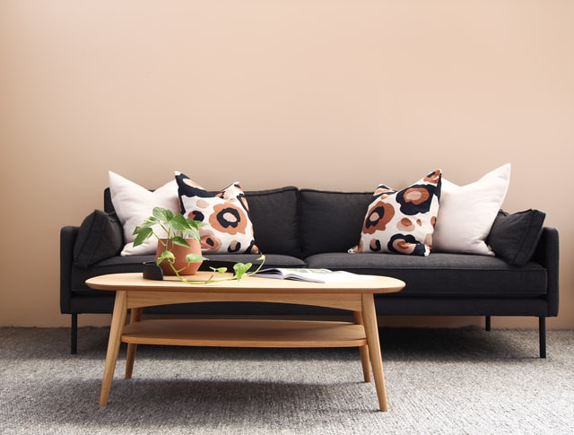 A simple coffee table in front of a big black sofa
